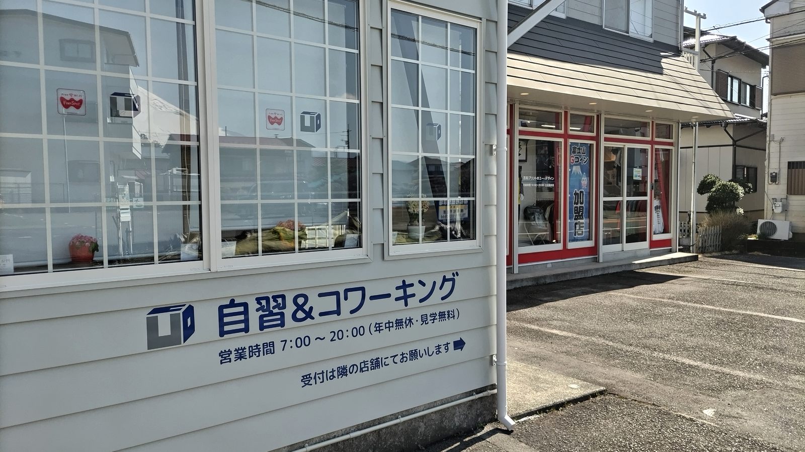 コワーキングスペースの壁面サインと、右隣にある赤い窓枠のユー・デザイン店舗